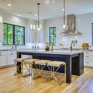 Kitchen island with bar stools and pendant lighting over quartz top.