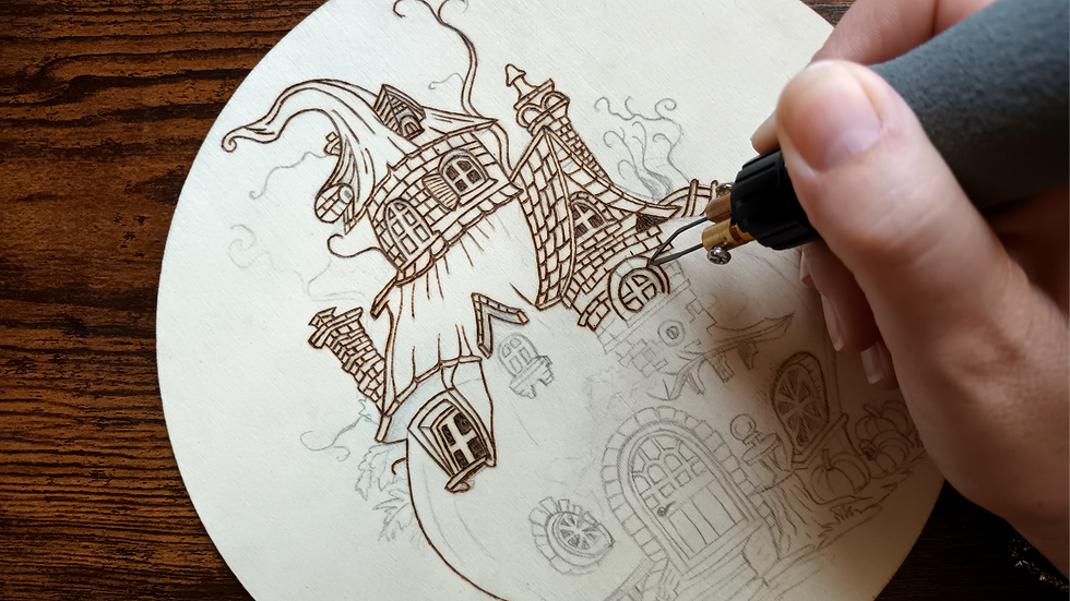 Miniature : Photo où on voit la créatrice de souffle ethéré en train de dessiner des détails de la maison citrouille au pyrograveur.