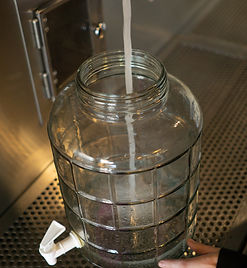filing structured alkaline water in glass bottle.