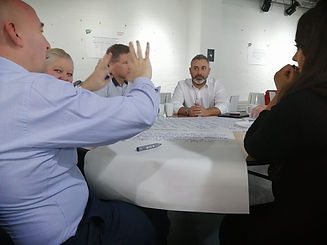 photo of people sitting around a table discussing ideas at a CIACIC workshop