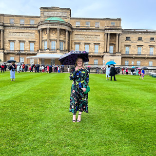 Gemma, in a summer dress on the grounds of Buckingham palace.