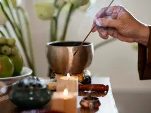 Side view of a man lighting incense stick