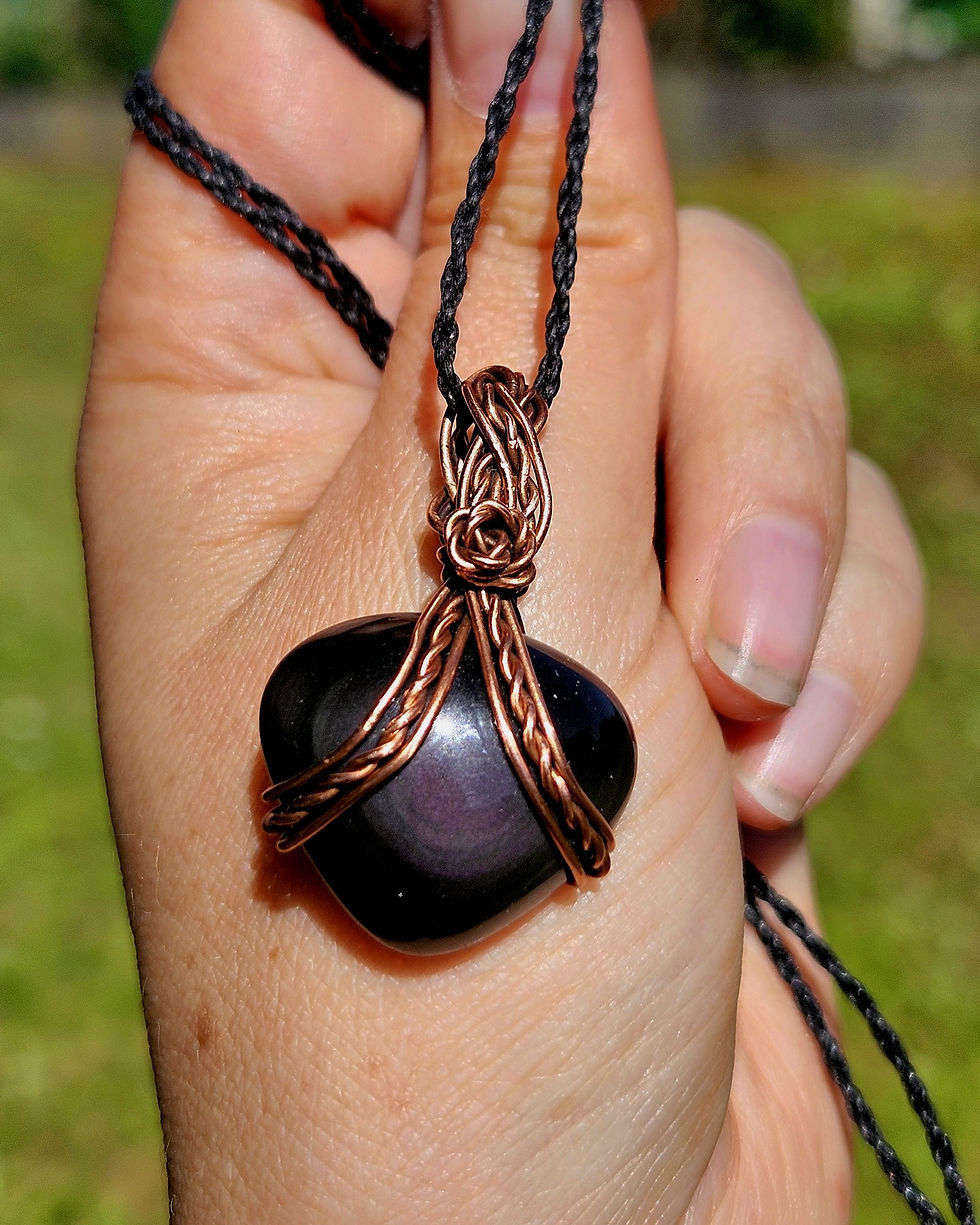 Miniature : petit pendentif elfique en obsidienne et cuivre tissé torsadé vue suspendu à une main