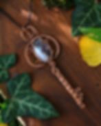 talisman pendentif sautoir en agate rubanée montée sur une structure de cuive tissé en fome de clef médiévale, vue de gauche