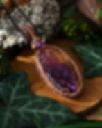 gros pendentif ovale en amétrine jaune et violette et cuivre tissé tressé, vue de gauche au soleil