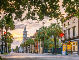 Downtown Charleston featuring colorful historic shops and buildings and iconic church in the background