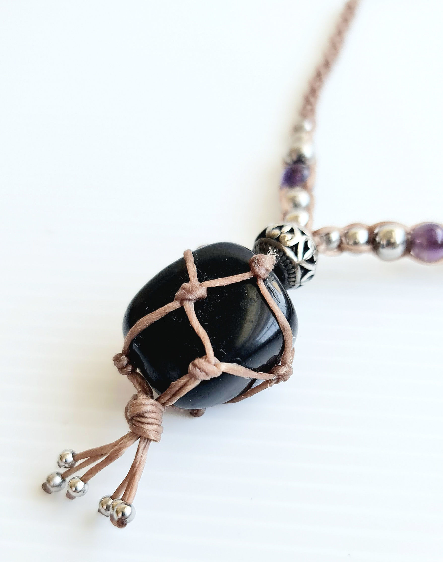Close-up of natural shungite stone in macrame crystal necklace