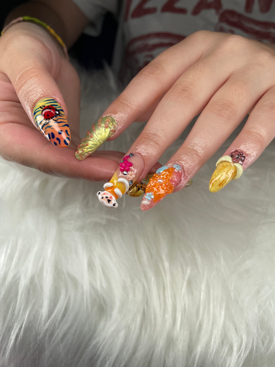 Hand with long, ornate 3D nail art