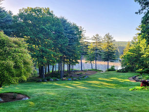 Morning view of a lush green landscape and lake in early summer at JenZen Living in Massachusetts, reflecting the cooling and grounding energy of the Ayurvedic summer season.