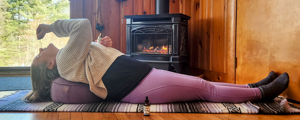 Woman gently applying Ayurvedic nasya oil while lying in supported fish pose to support sinus clearing, mental clarity, and relaxation
