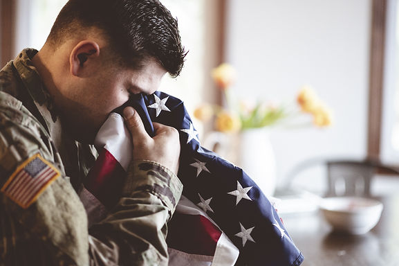 american-soldier-mourning-praying-with-american-flag-his-hands.jpg