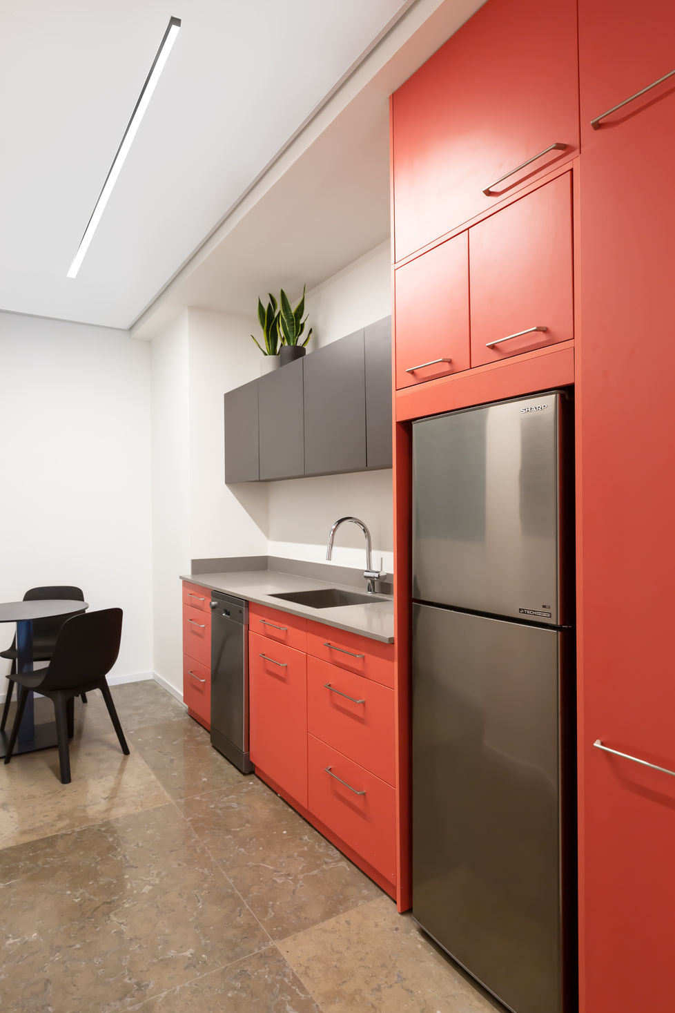 מטבח אדום בוהק במשרד עו״ד. שבירה של העיצוב המוקפד ביתר החללים