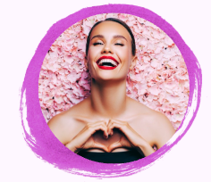 A woman smiling while creating heart sign with hands