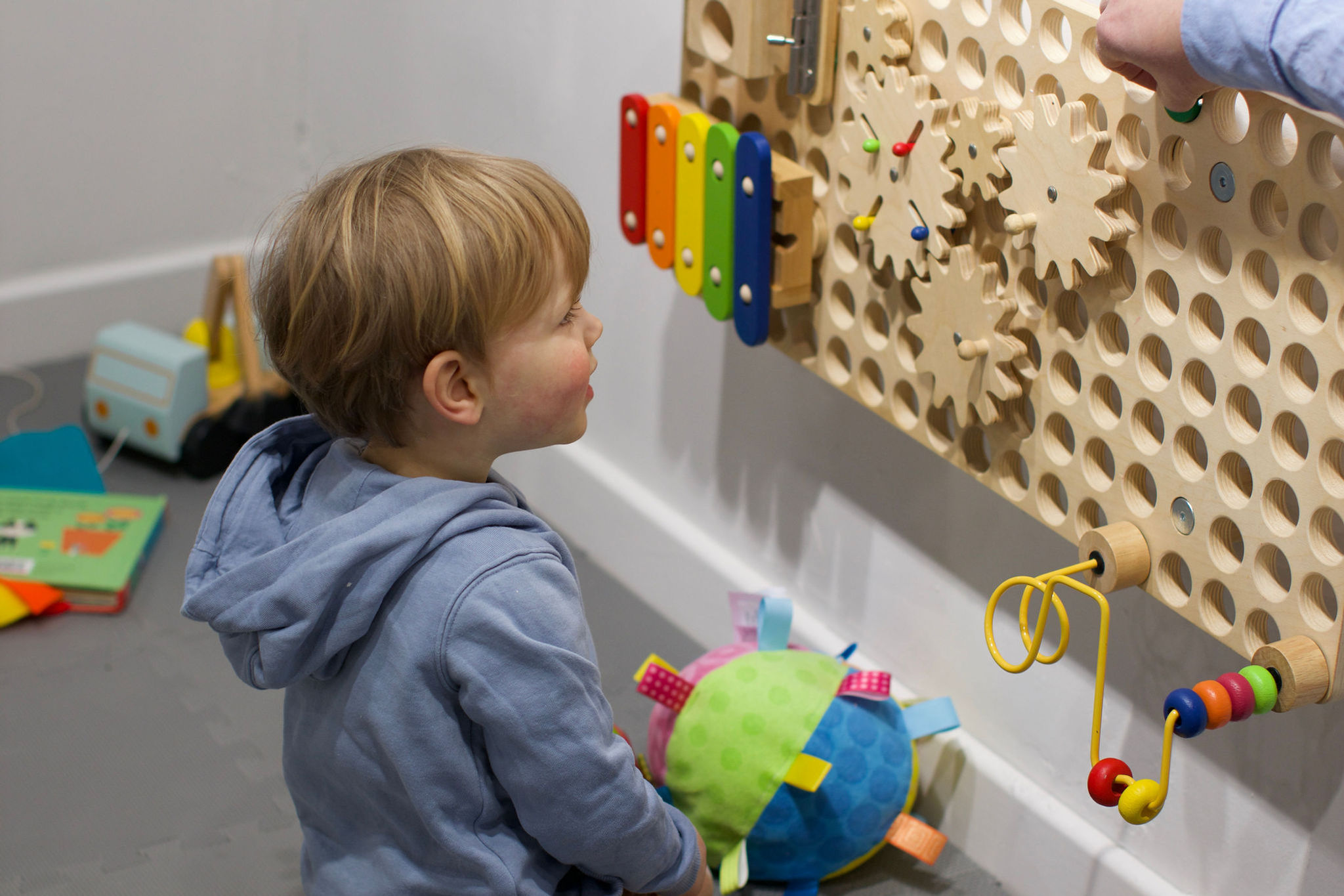 Boy in front of a multi activity educational board