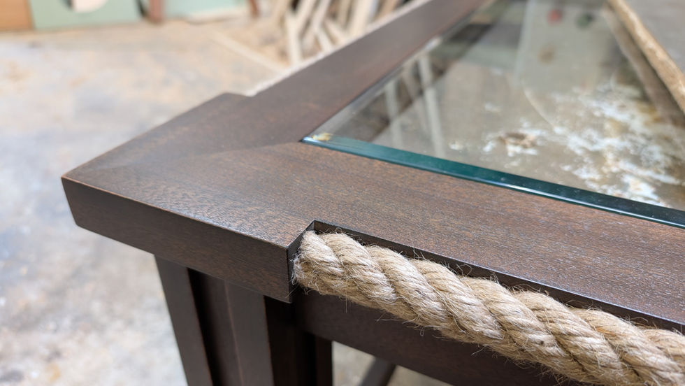 Metal and glass table corner with rope detail.