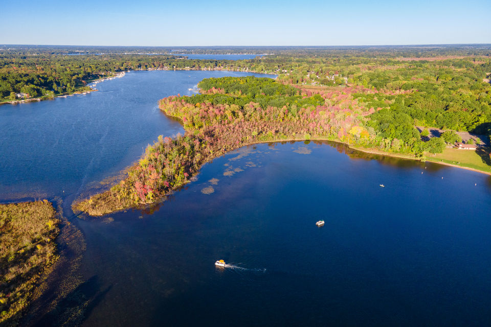 Aerial view of a tranquil lake surrounded by green foliage in Michigan