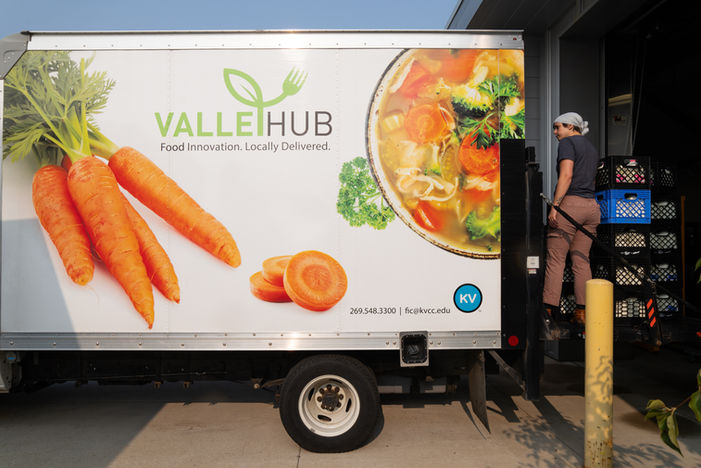 A ValleyHub truck featuring carrots, soup, and produce at a loading dock