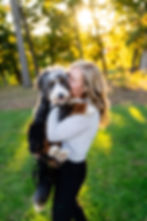 woman kissing her Bernedoodle puppy at a photography session in Kalamazoo Michigan