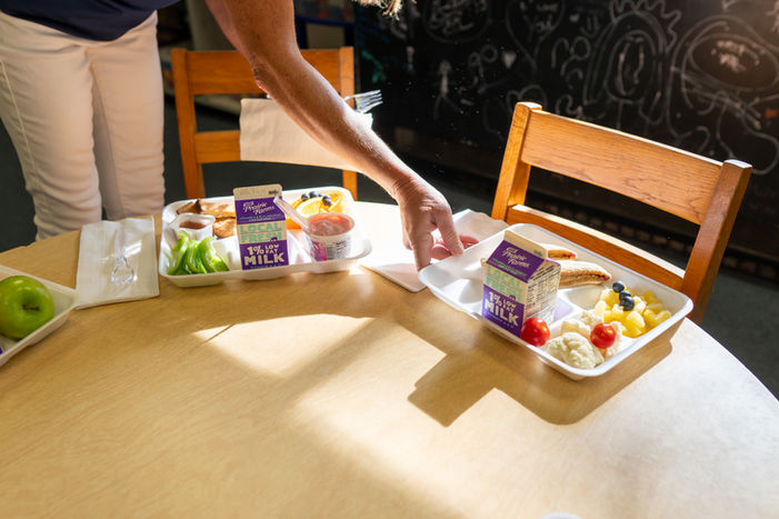 School lunch trays with fresh food served on a table as part of a farm-to-school meal program in Michigan.