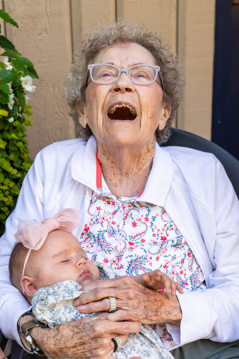Great-grandmother holding a sleeping baby during a candid family photography session