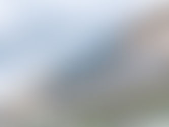 Sign reading "Back to Hearing" on a building under a cloudy sky. Storefront advertises hearing services like hearing test and earwax removal.