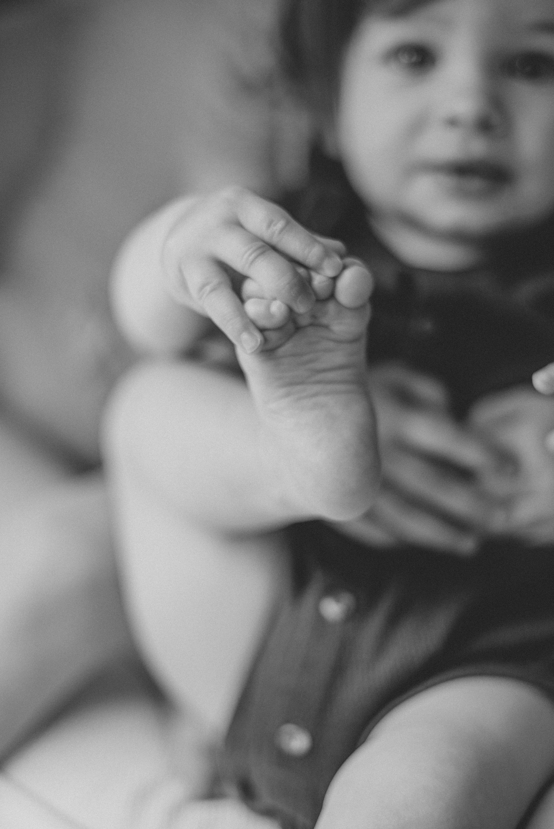 a detail shot of a baby holding his foot
