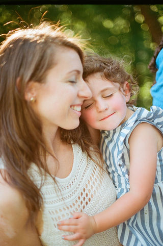 a girl resting her head on her mom's cheek during a sunset photography session with charlottesville family photographer Laura Richards