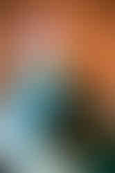 girl looks off to the side while standing beside her mom in a gelato shop