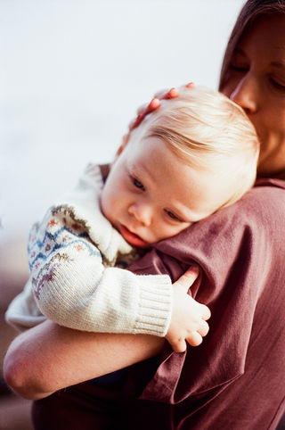 a baby resting his head on his mother's shoulder during a sunrise family session with charlottesville photographer Laura Richards