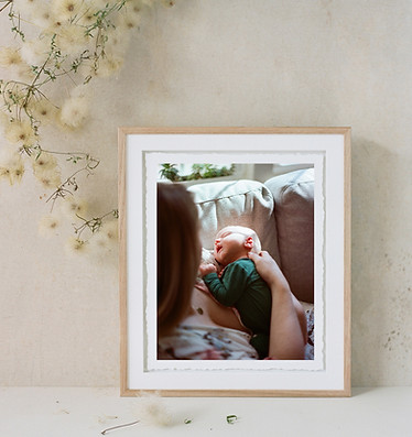 A beautiful handmade Italian wood frame with a hand-torn print of a mother holding her newborn on a couch bathed in sun