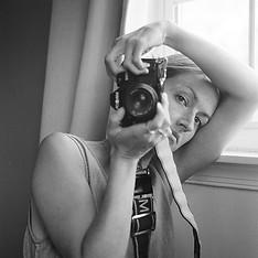 charlottesville family and newborn photographer laura richards looking at camera while holding a film camera