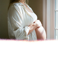 mom's pregnant belly in the window sunlight