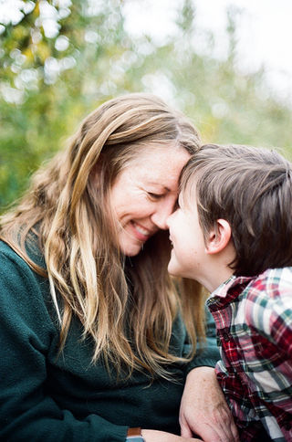 mom and son resting their foreheads against each other during a family photo session at carter mountain orchard with charlottesville family photographer Laura Richards