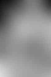 A black and white close-up of a mom touching her newborn's hand