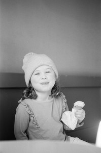 girl smiles at camera while holding a cone of gelato