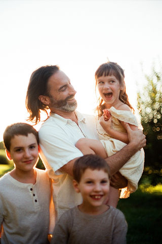 a young girl laughing joyfully while her dad holds her during a family photo session in charlottesville virginia