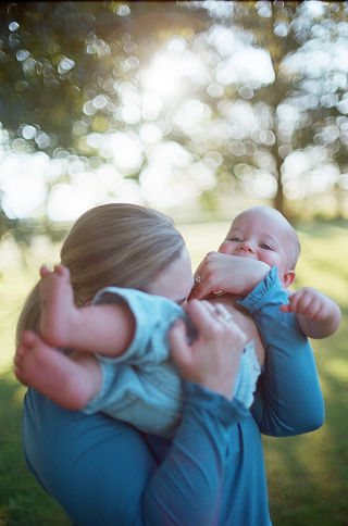 a mom kissing her baby's belly during a sunset family photography session with charlottesville photographer Laura Richards