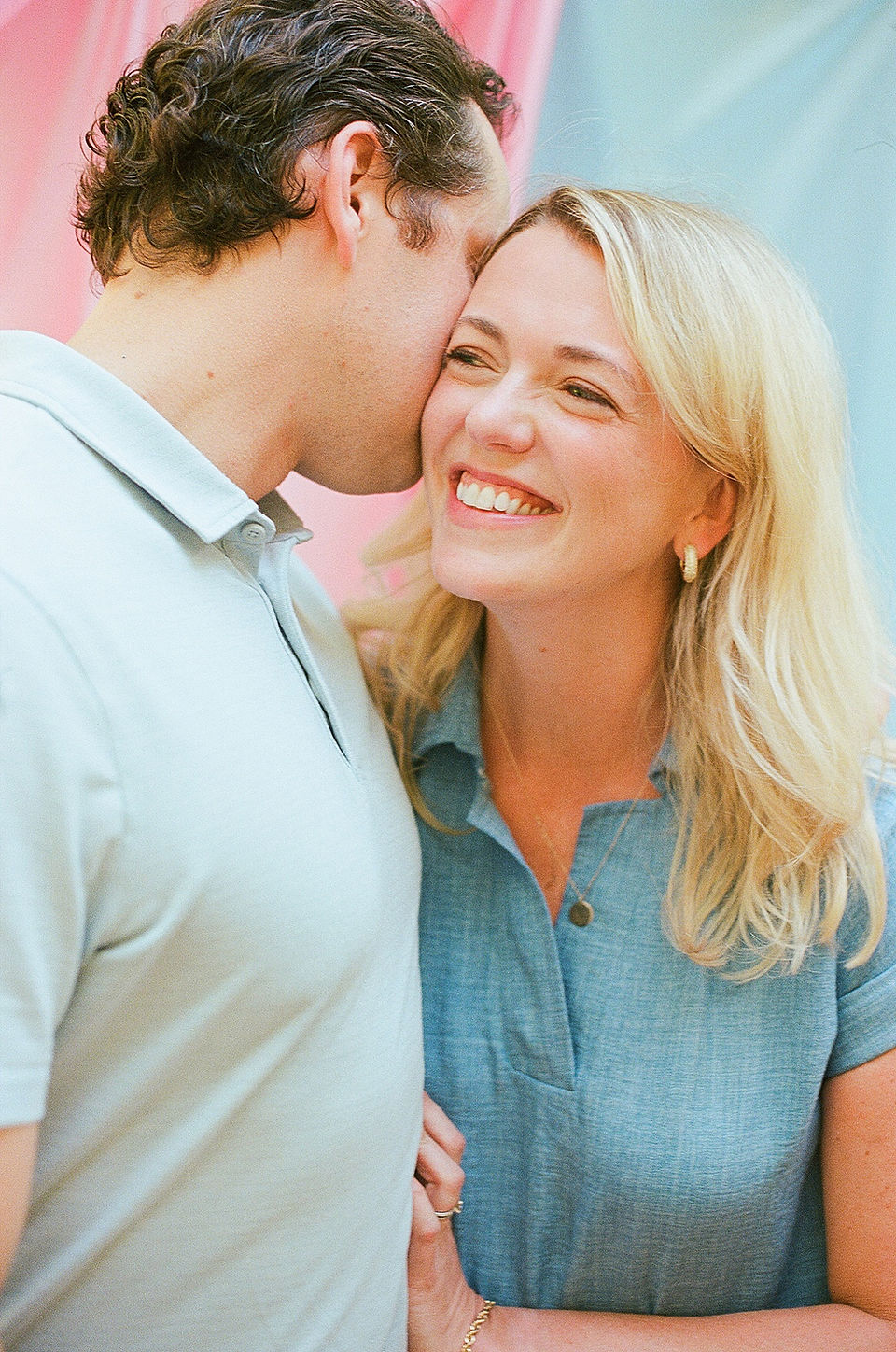 a woman smiles as her husband rests his cheek on her face during relaxed family photos in charlottesville virginia