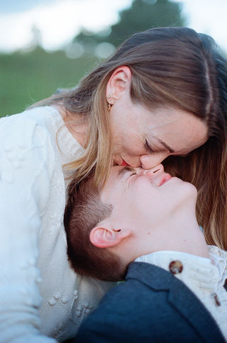 A mom kissing her son's forehead during a family photography session at Boar's Head Resort in Charlottesville, Virginia
