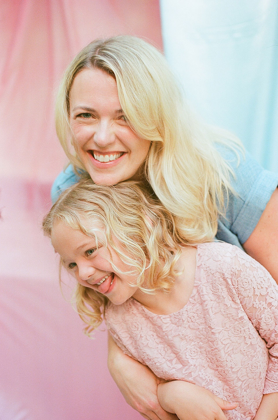 a mom smiles at the camera with her daughter during natural family photos in charlottesville virginia