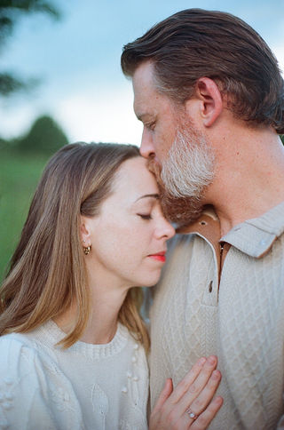 a husband kissing his wife's forehead during a family photo session at boar's head resort with charlottesville virginia photographer Laura Richards