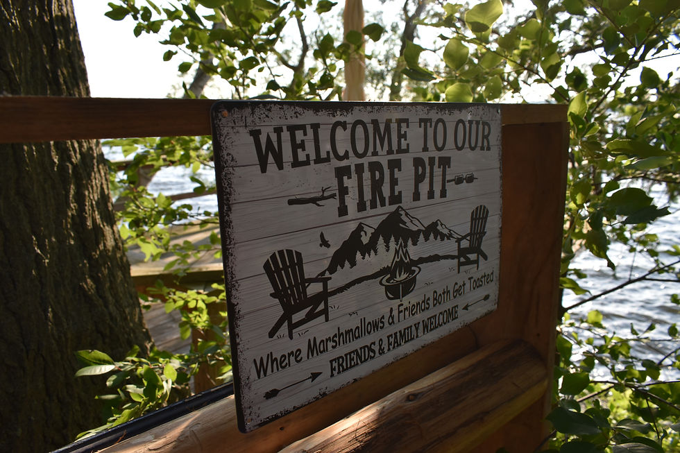 Firepit area sign at The Blue Heron Cottage with lake view in the background, cozy outdoor space for relaxing evenings in Ontario cottage country
