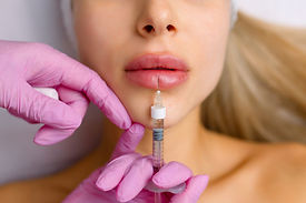 Injection procedure for lip augmentation, close-up. The cosmetologist slowly and carefully