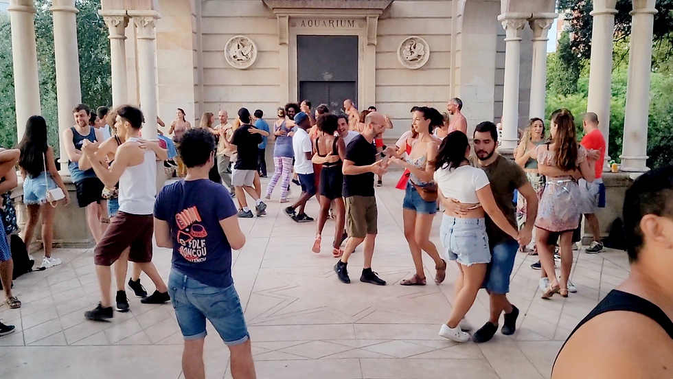 People dancing forró outdoors in a Barcelona park during the afternoon.