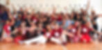 Large group of people posing for a photo at the end of a forró workshop in a dance studio in New York City, many wearing Forró New York Weekend festival shirts.