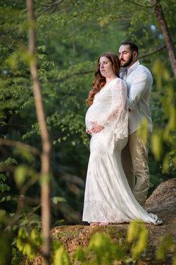 Couple standing on cliff looking out across water