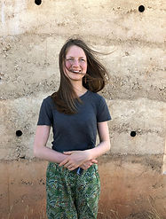 Photo of architect, with Zumthor as background. Wearing homemade trousers with liberty fabric
