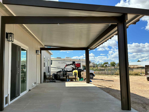 Patio cover extension with a view of a home's backyard and RV.