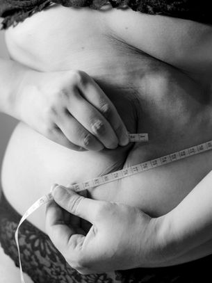 A person measuring their own waist