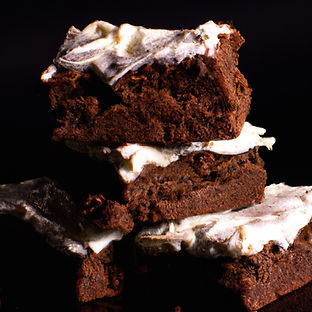 baked brownies with white frosting with black background.jpg